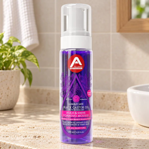 Allored Professional Jamaican Black Castor Oil & Rosemary Foaming Mousse with Lightweight Hold for Curly, Coily & Wavy Hair — 200 ml on a bathroom vanity.