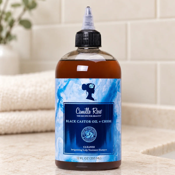 Camille Rose Black Castor Oil + Chebe Scalp Treatment Shampoo for Stronger, Healthier Hair — 12 oz on a bathroom vanity.
