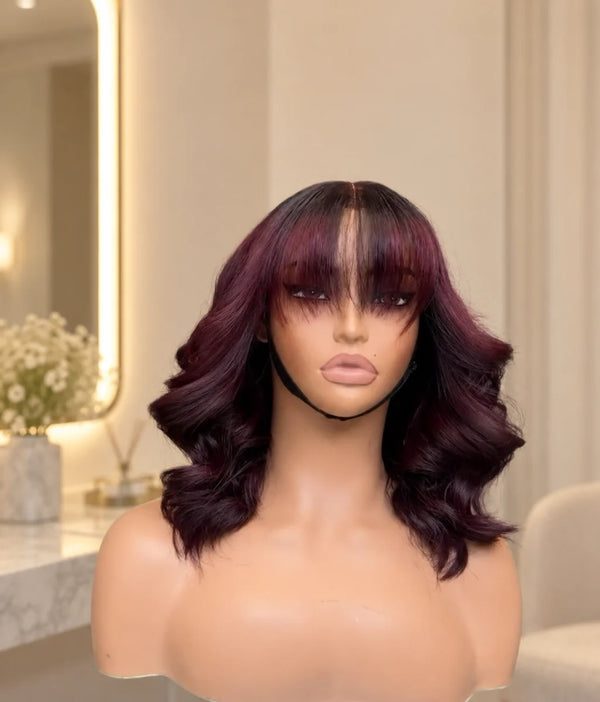Chic Luxe Hair Wavy Fringe Bob Wig, shown on its original subject against a neutral dressing-room background.
