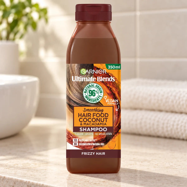 Garnier Hair Food Coconut & Macadamia Shampoo, Nourishing & Smoothing for Dry, Frizzy Hair — 350 ml on a bathroom vanity.