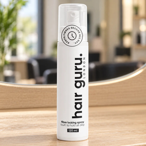 Hair Guru 120ml fibre locking spray bottle on a salon worktop.