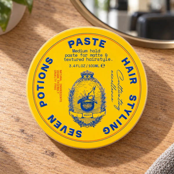 Seven Potions hair styling paste tin on a salon worktop.