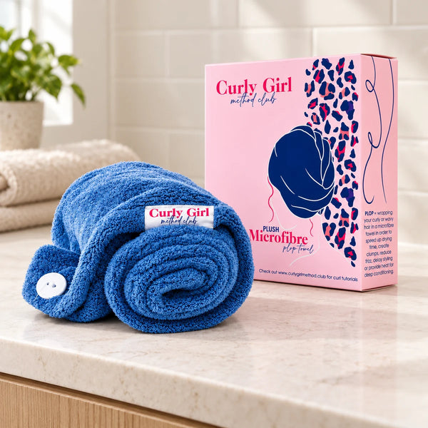 Blue microfibre hair towel wrap with its source box on a bathroom vanity.