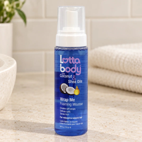 Lottabody Wrap Me Foaming Mousse for Defined Curls, Shine & Frizz Control for All Hair Types — 7 oz on a bathroom vanity.