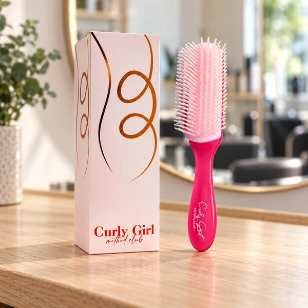 Pink styling brush with its source box on a salon worktop.