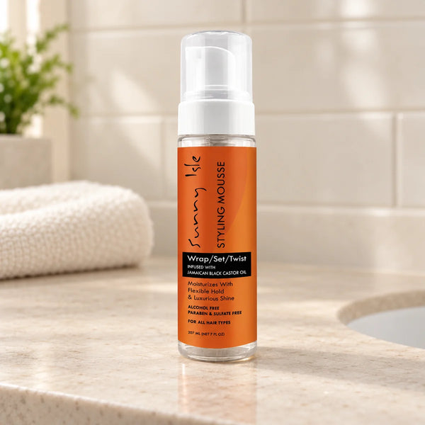 Sunny Isle Jamaican Black Castor Oil Mousse — 7 oz on a bathroom vanity.