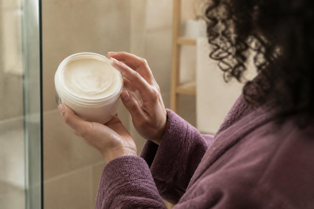 Assorted hair care bottles and jars arranged on a white surface with soft natural lighting