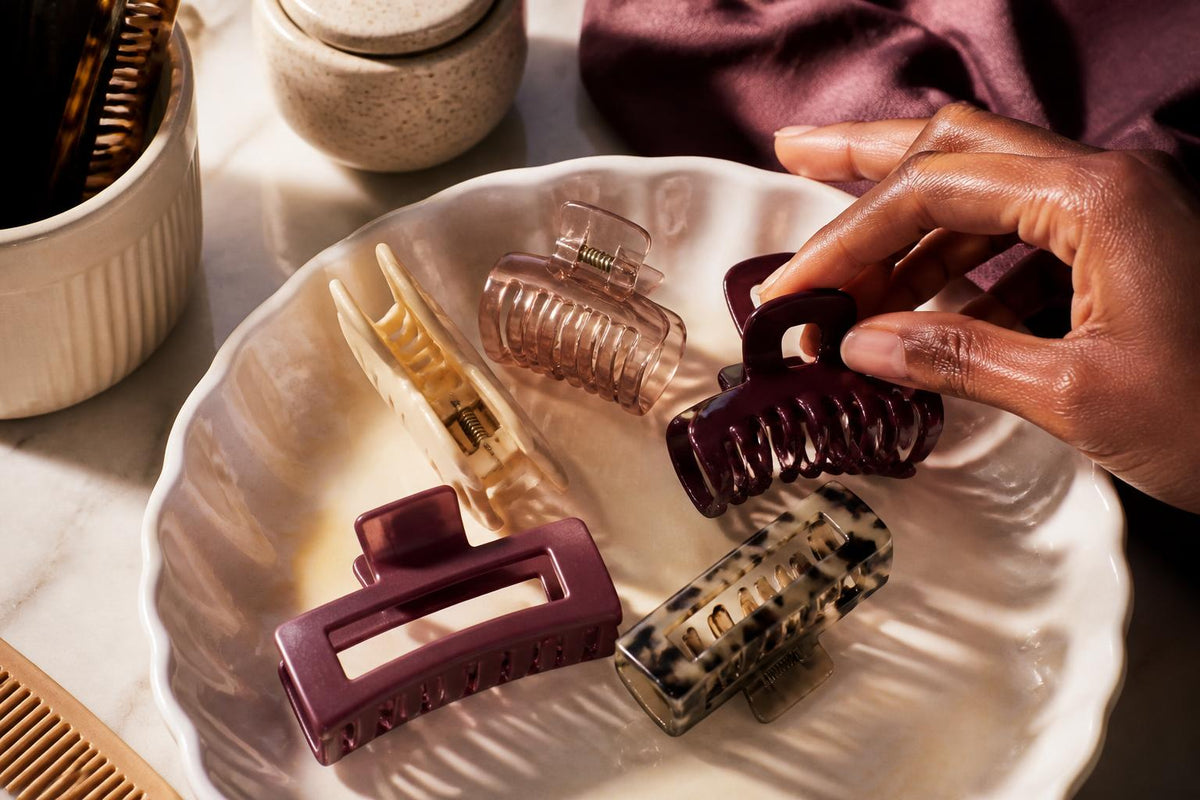 A selection of colorful hair clips arranged neatly on a textured beige surface