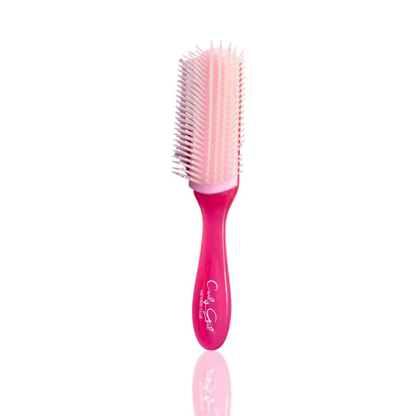 Pink CurlyGirlMethodClub styling brush with white bristles on a white background