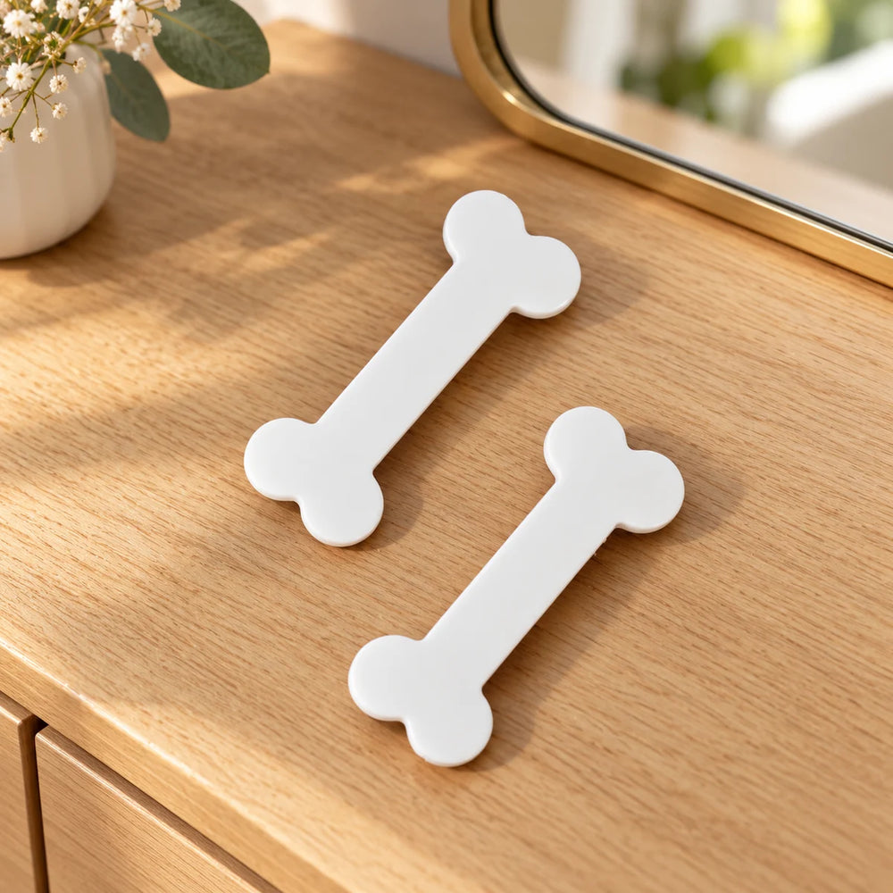 Set of two white bone hair clips on a wooden dressing table.
