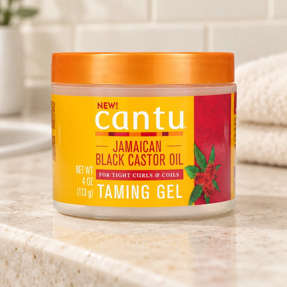 Cantu Jamaican Black Castor Oil Taming Gel — 4 oz on a bathroom vanity.