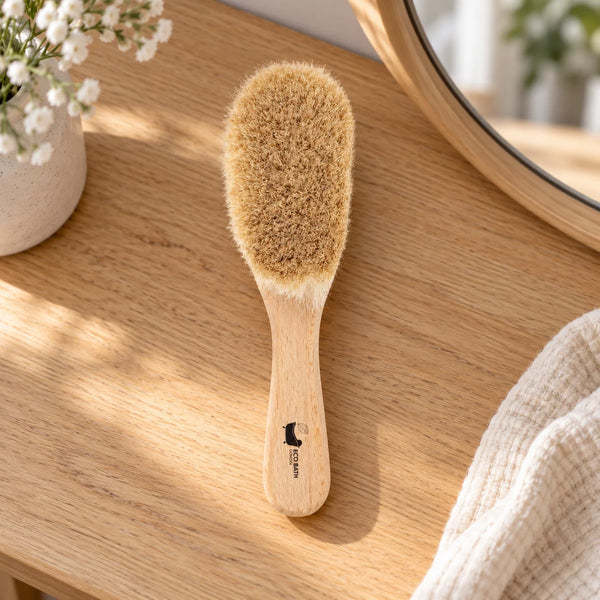 Eco Bath goat-bristle baby hair brush on a wooden dressing table.