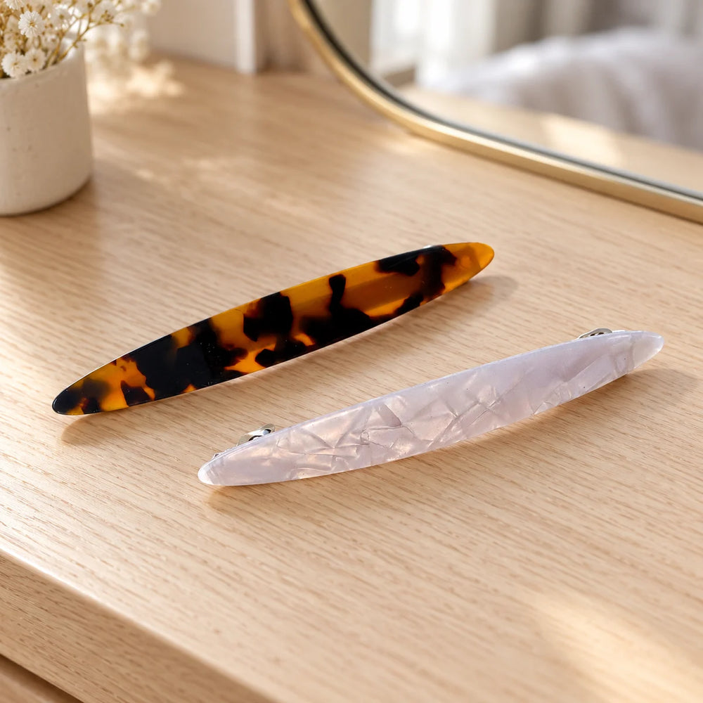 Reverie Hair Fine Line Hair Clip — Fine Line hair barrettes, white and tortoiseshell Set of 2, on a dressing table.