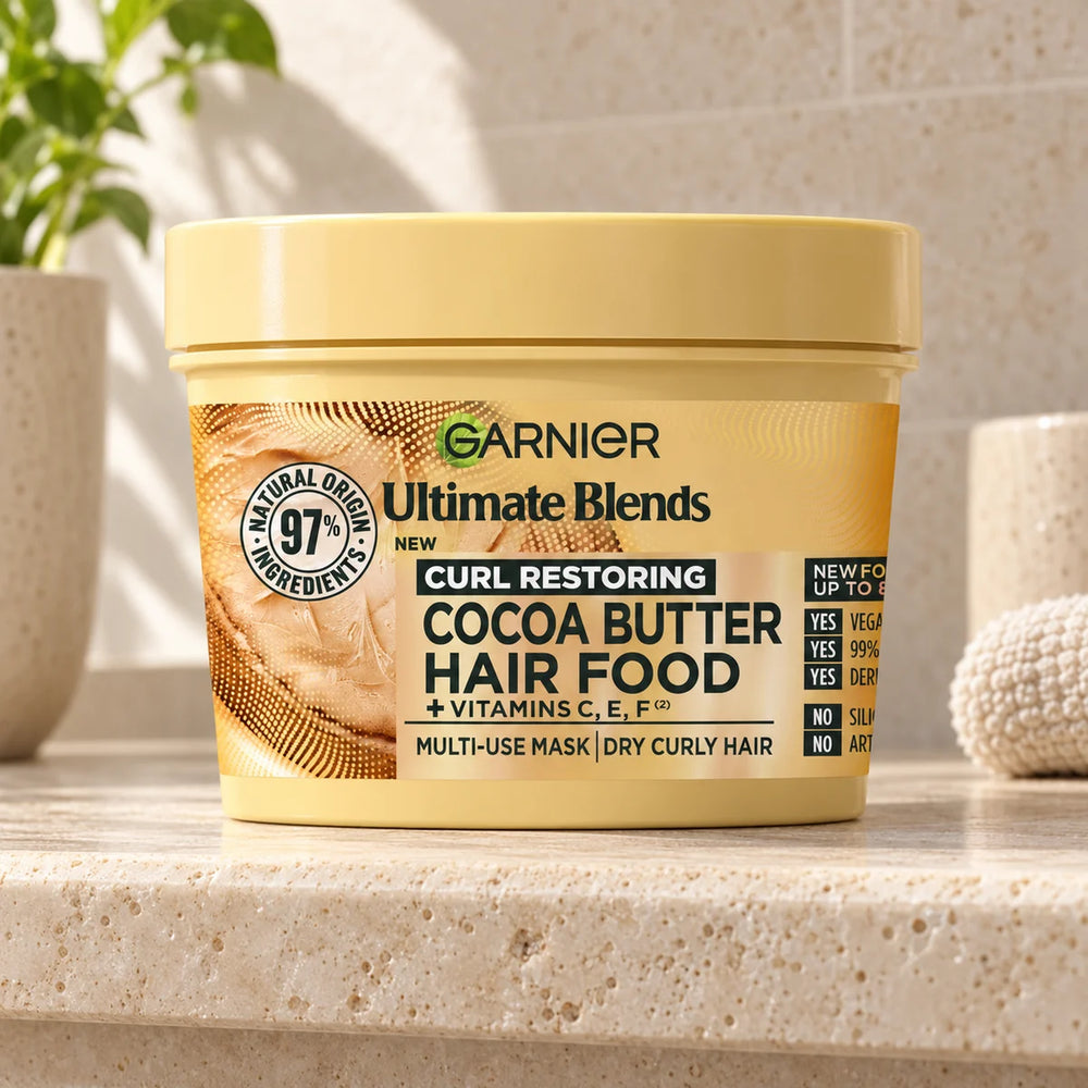 Garnier Cocoa Butter Hair Food: Deeply Nourishing 3-in-1 Hair Mask for Dry, Frizzy Hair — 390 ml on a bathroom vanity or dressing table.