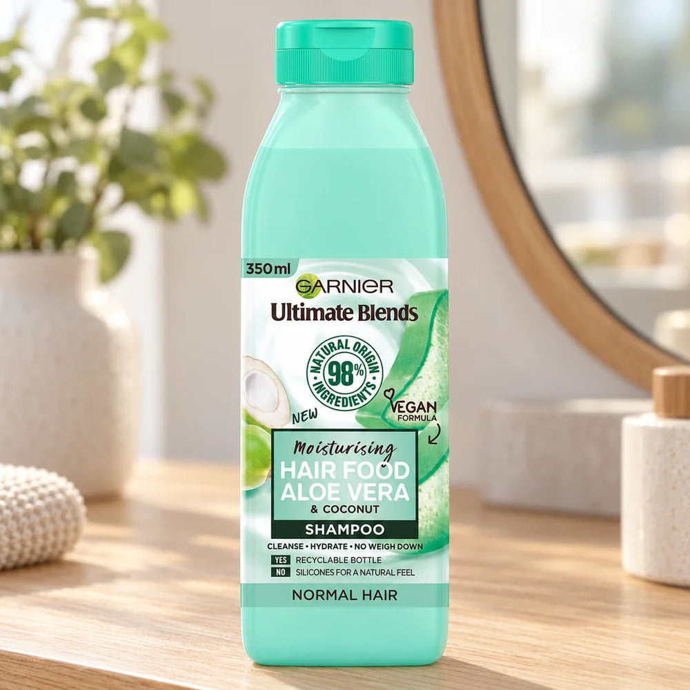 Garnier Hair Food Aloe Vera Shampoo Hydrating & Softening for Dry, Normal & Dull Hair — 350 ml on a bathroom vanity or dressing table.