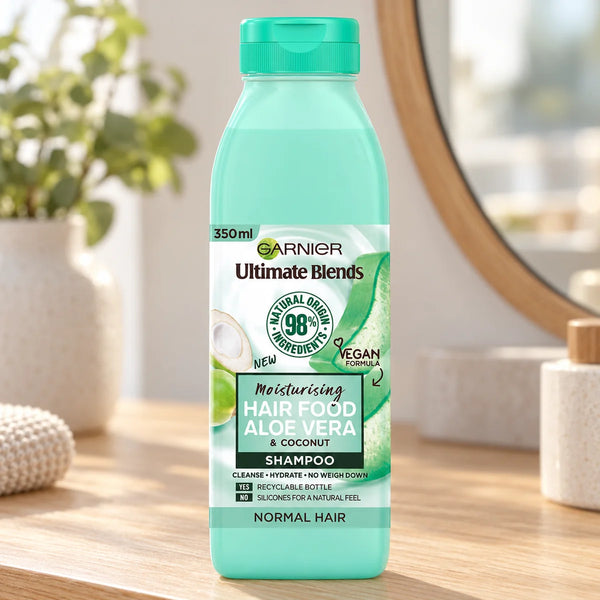 Garnier Hair Food Aloe Vera Shampoo Hydrating & Softening for Dry, Normal & Dull Hair — 350 ml on a bathroom vanity or dressing table.