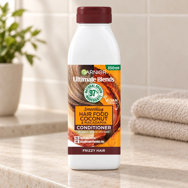 Garnier Hair Food Coconut & Macadamia Conditioner: Nourishing & Smoothing for Dry, Frizzy Hair — 350 ml on a bathroom vanity.
