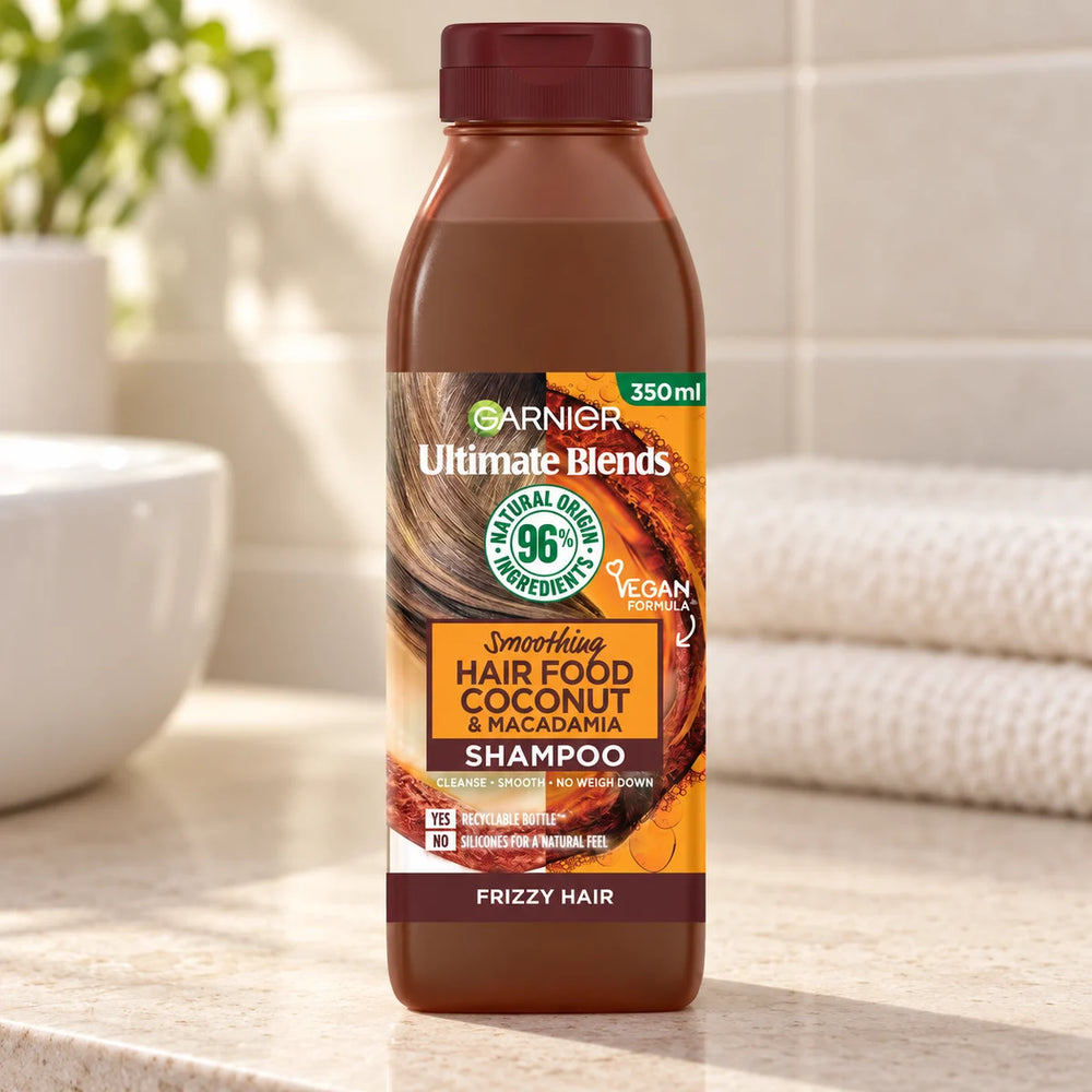 Garnier Hair Food Coconut & Macadamia Shampoo, Nourishing & Smoothing for Dry, Frizzy Hair — 350 ml on a bathroom vanity.
