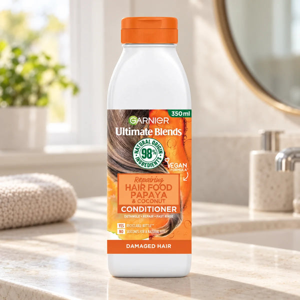 Garnier Hair Food Papaya & Coconut Repairing Conditioner for Damaged & Dry Hair — 350 ml on a bathroom vanity.