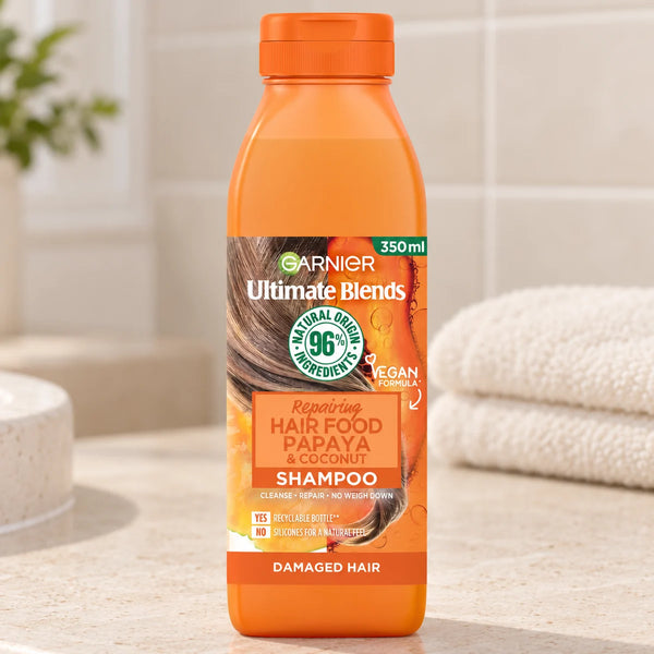 Garnier Hair Food Papaya & Coconut Repairing Shampoo for Damaged Hair — 350 ml on a bathroom vanity.