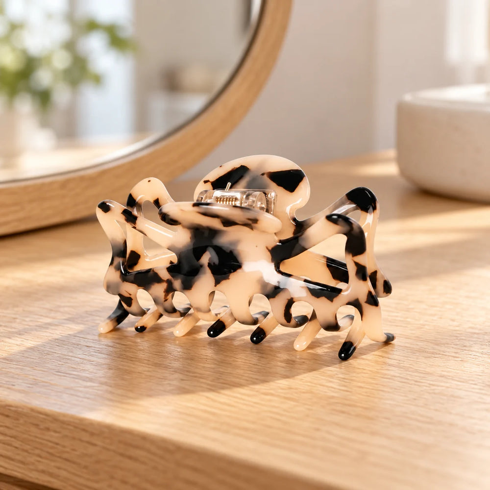Tortoiseshell acetate hair claw on a wooden dressing table.