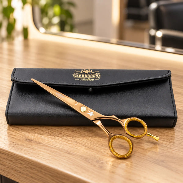 Barbarossa rose-gold cutting scissors with case on a salon worktop.