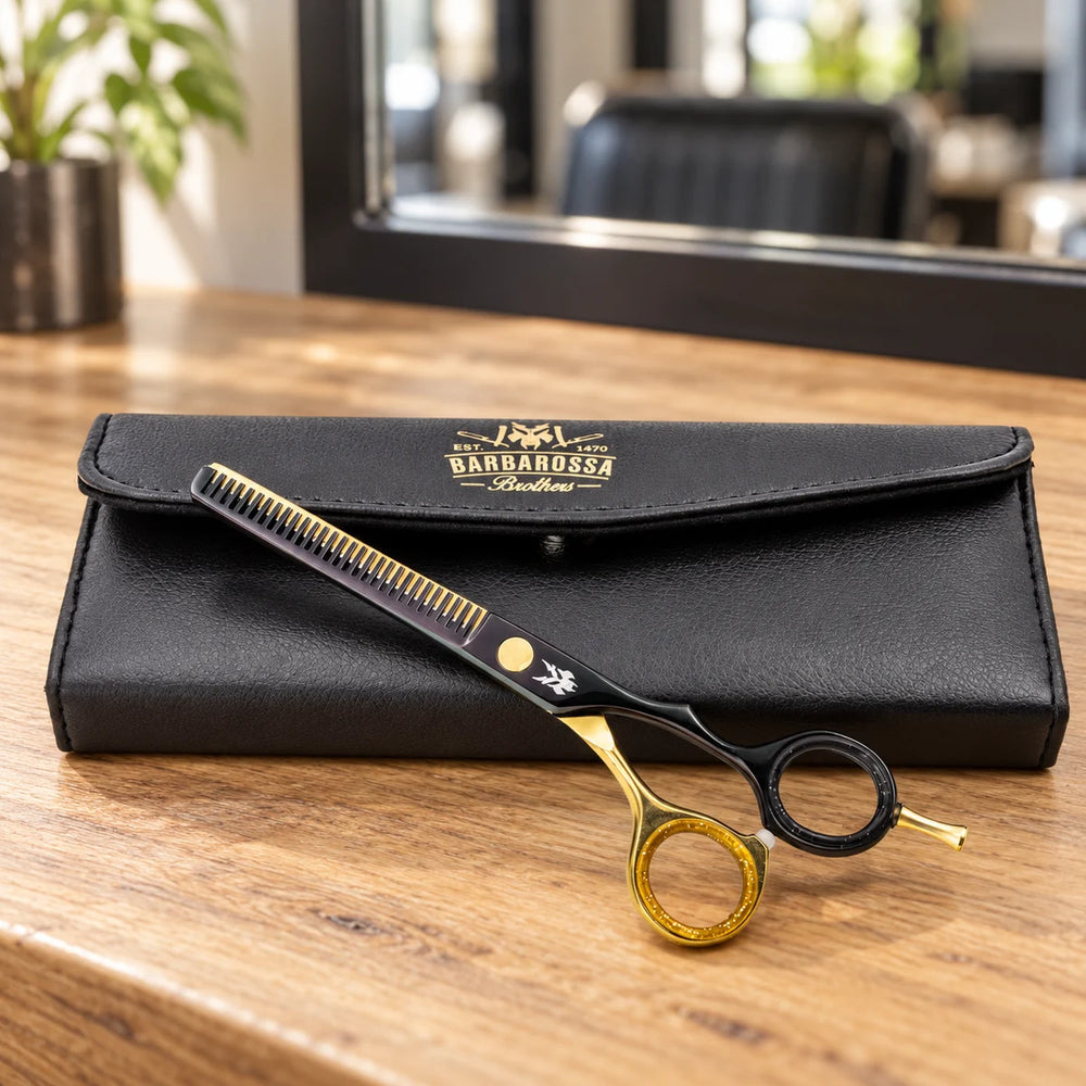Barbarossa black and gold thinning scissors with case on a salon worktop.