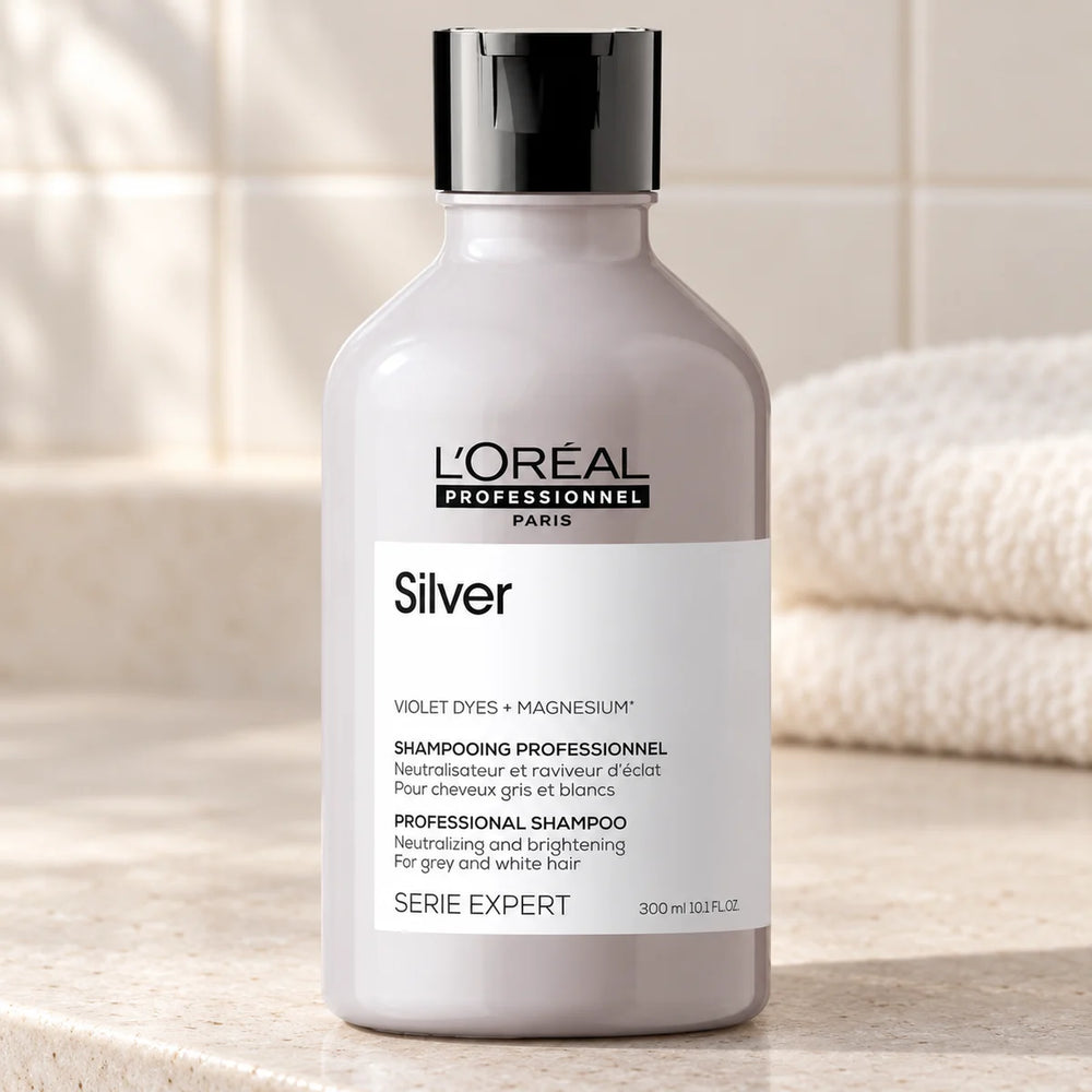 L'Oréal Professionnel Serié Expert Silver Shampoo Neutralises Yellow Tones & Brightens for Grey, White, and Light Blonde Hair — 300 ml on a bathroom vanity.