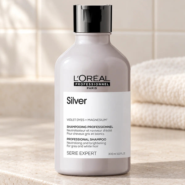 L'Oréal Professionnel Serié Expert Silver Shampoo Neutralises Yellow Tones & Brightens for Grey, White, and Light Blonde Hair — 300 ml on a bathroom vanity.