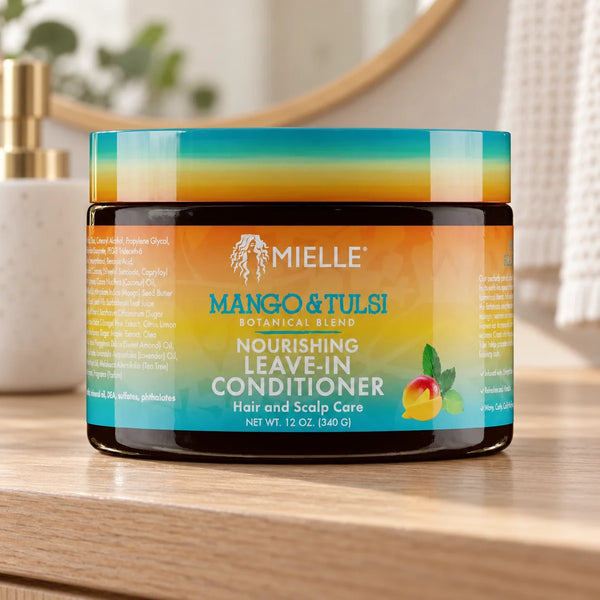 Mielle Mango & Tulsi Leave-In Conditioner — 12 oz on a bathroom vanity.