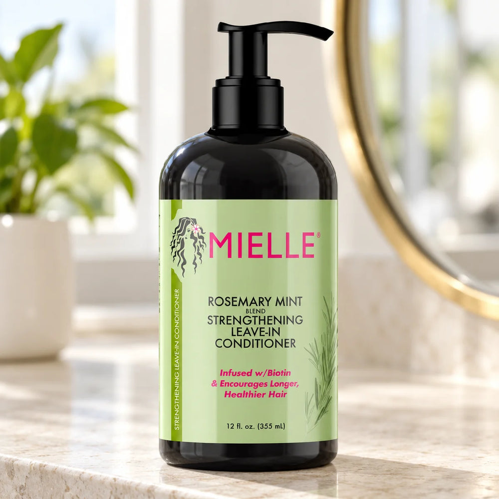 Mielle Rosemary Mint Strengthening Leave-In Conditioner — 12 oz on a bathroom vanity.