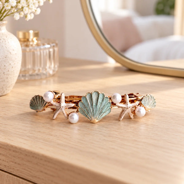 Reverie Hair Oceana Hair Clip — Oceana pearl and seashell hair clip on a dressing table.
