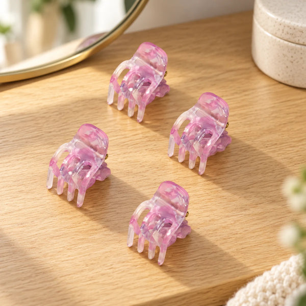 Four pink mini root claw clips on a wooden dressing table.