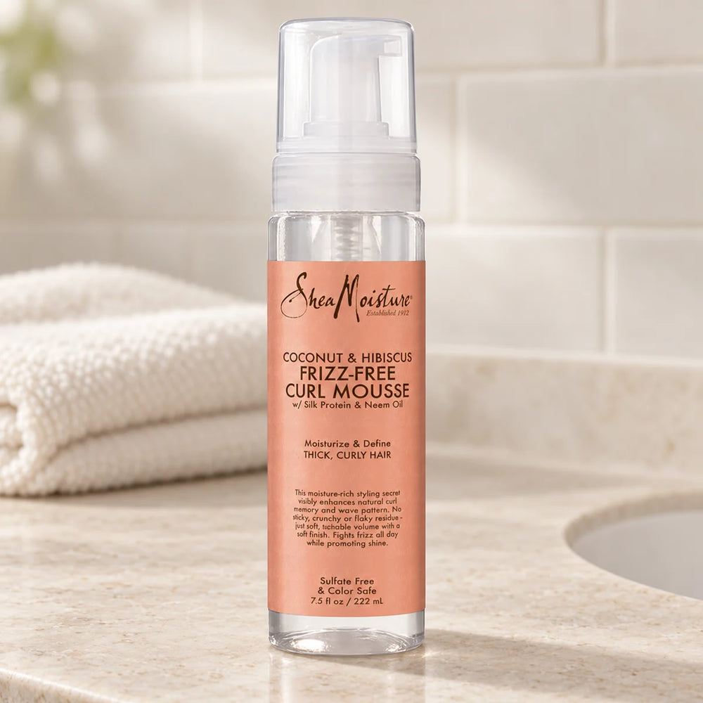 Shea Moisture Coconut & Hibiscus Frizz-Free Curl Mousse — 7.5 oz on a bathroom vanity.