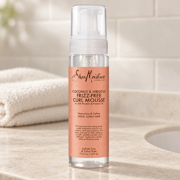 Shea Moisture Coconut & Hibiscus Frizz-Free Curl Mousse — 7.5 oz on a bathroom vanity.
