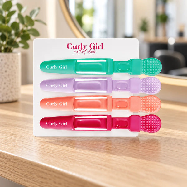 Set of four sectioning clips on a salon worktop.