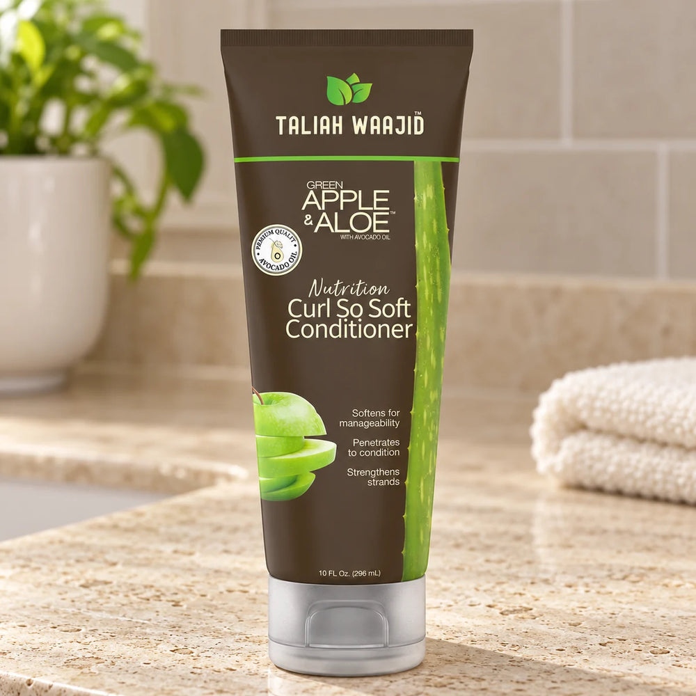 Taliah Waajid Green Apple & Aloe Nutrition Curl So Soft Conditioner Deeply Nourishes & Softens Curls for Wavy, Curly & Coily Hair — 10 oz on a bathroom vanity.