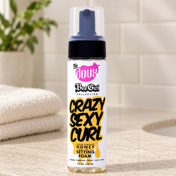 The Doux Crazy Sexy Curl Honey Setting Foam 7oz All-in-1 Styling Mousse — 7 oz on a bathroom vanity.